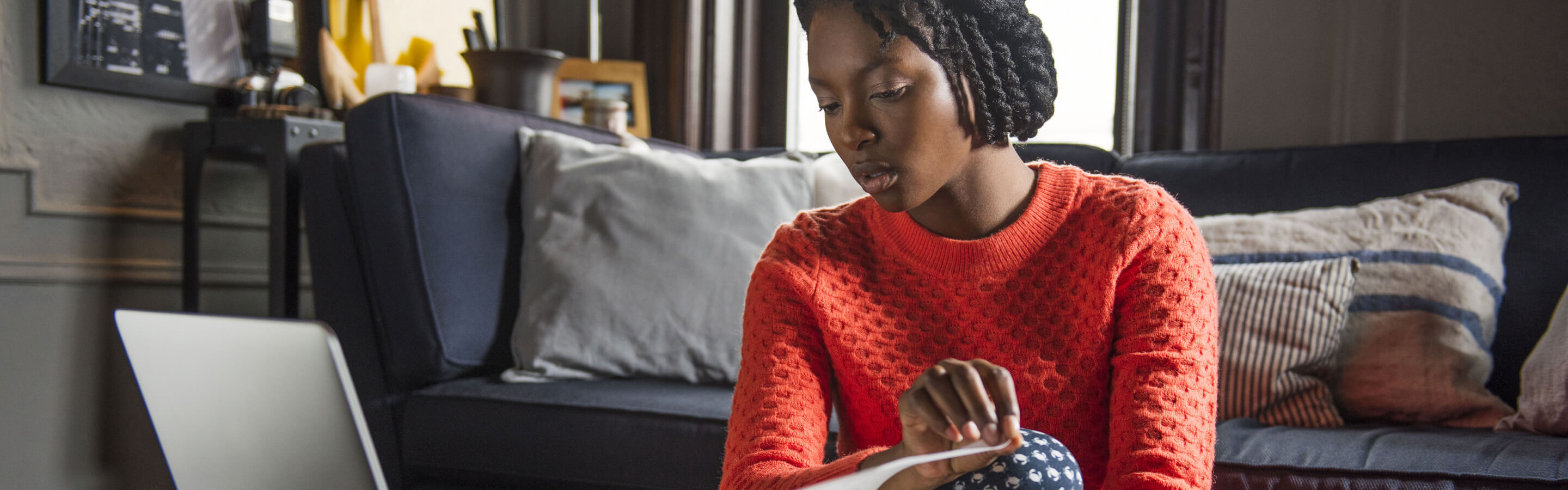 woman in orange sweater taking notes