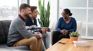 people sitting across a table talking and smiling