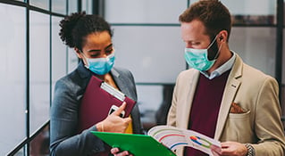 Two work colleagues looking over materials