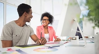 Two ladies smiling at desk