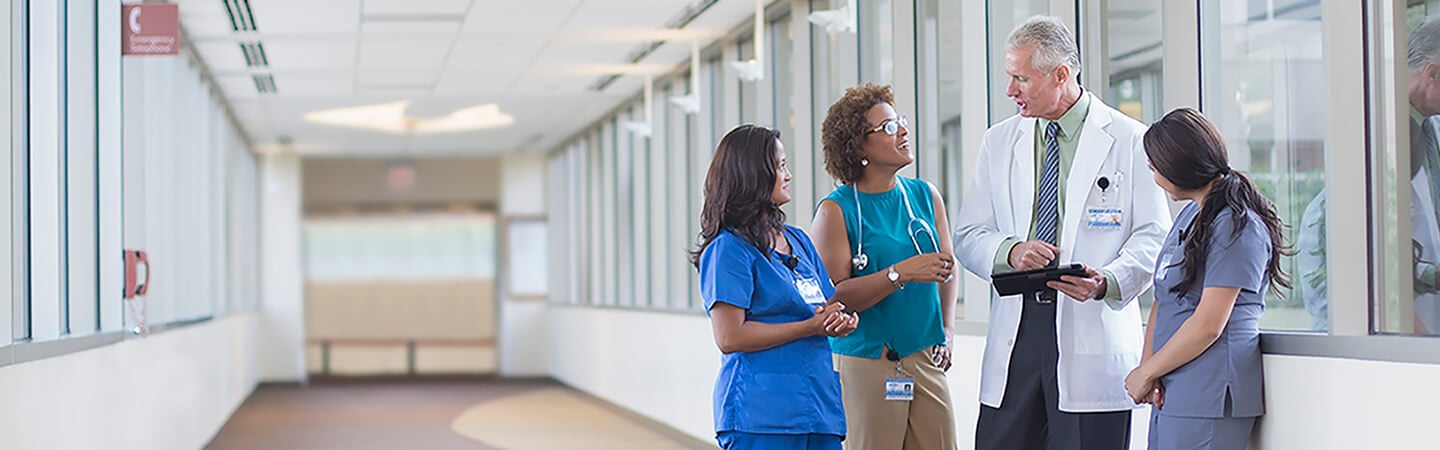 Health care professionals talking in hospital hallway