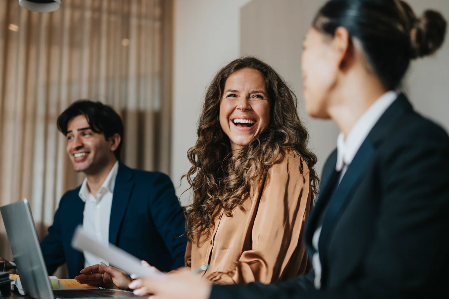 Coworkers laughing in meeting room