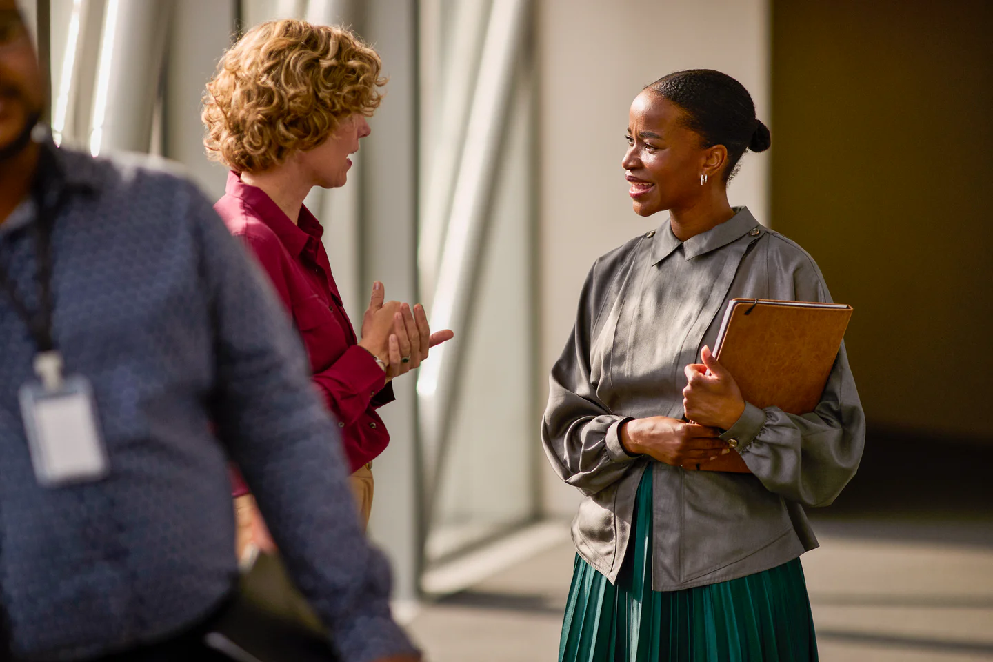 Portrayal of Capella student talking to coworker in an office hallway.