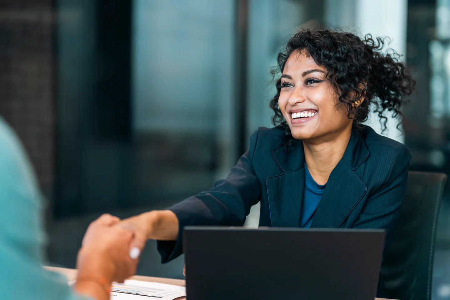 Portrayal of Capella business student shaking hands at a meeting.