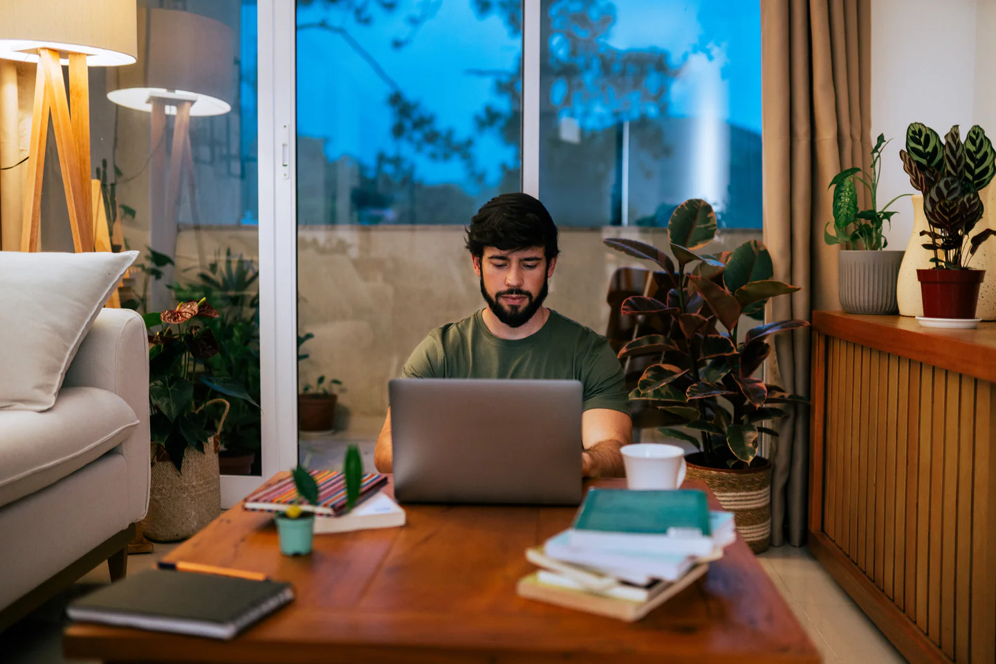 Portrayal of Capella student with laptop, books and coffee learning comfortably at home.