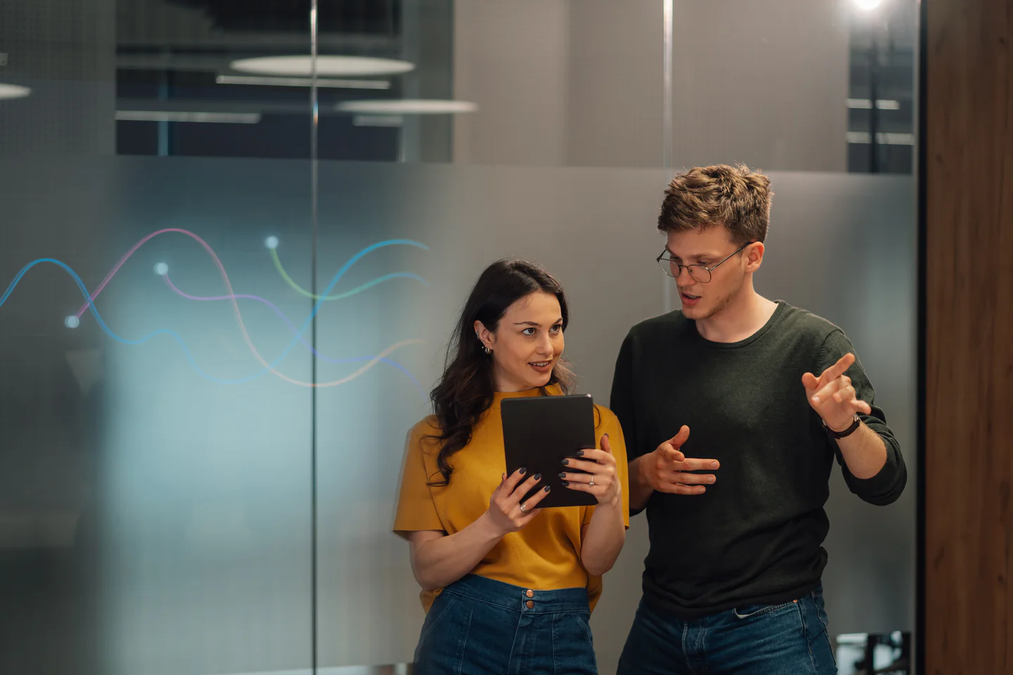 Portrayal of Capella student talking to a colleague while looking at a tablet.