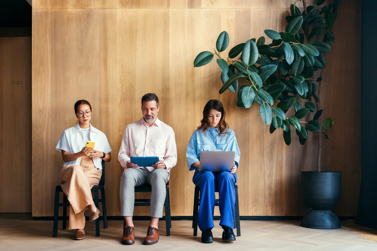 Portrayal of Capella student seated next to coworkers in chairs.