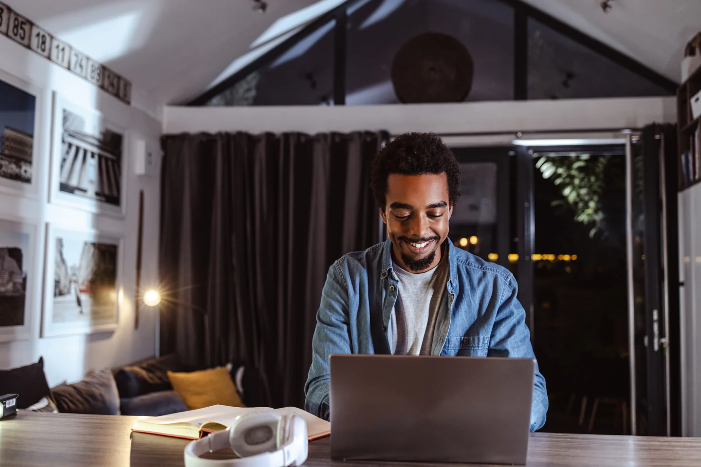 Portrayal of Capella student working at table in apartment during the evening.