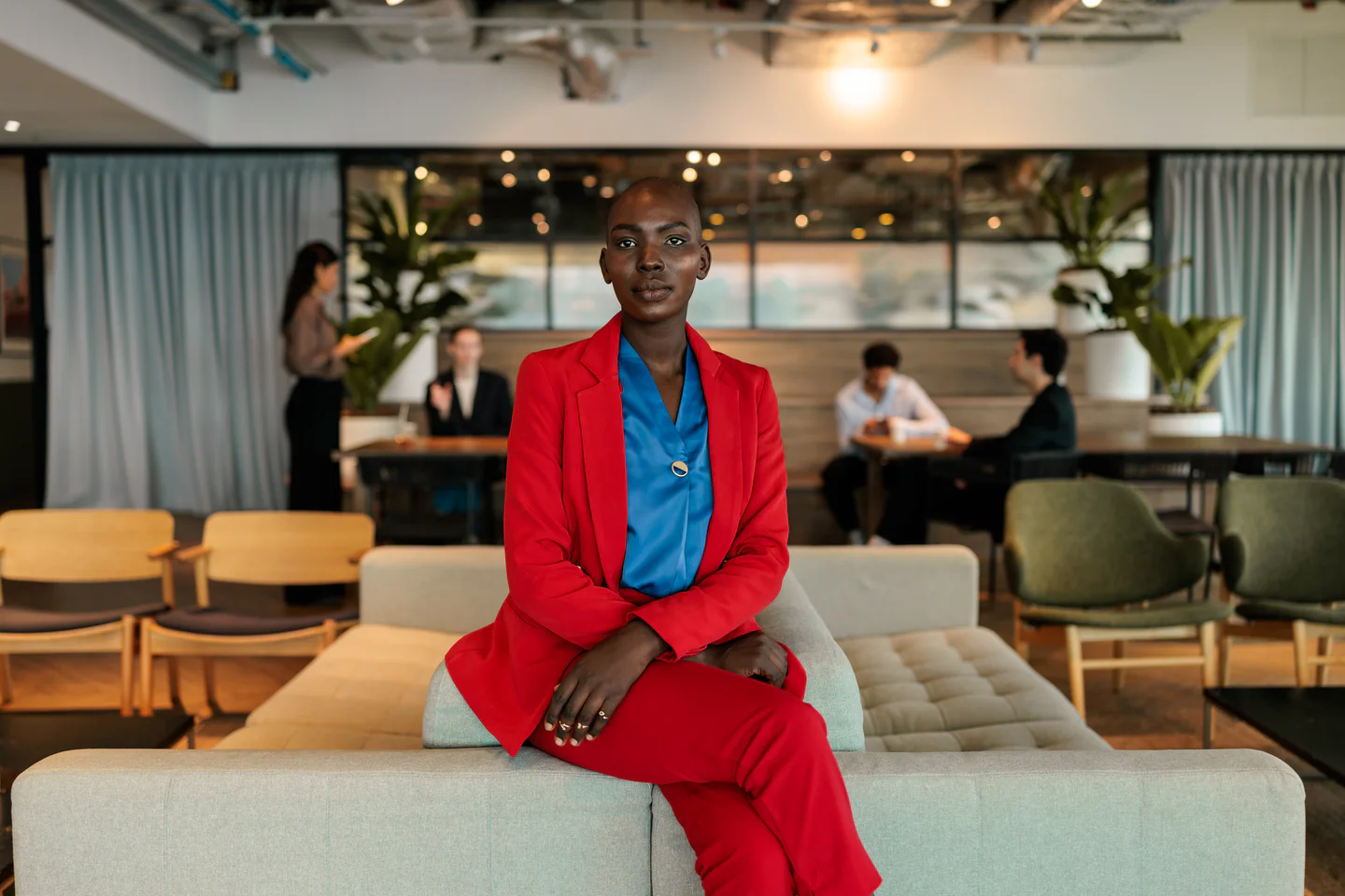 Portrayal of Capella business student sitting on the arm of a sofa.