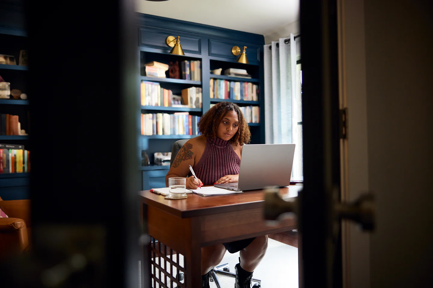 Portrayal of Capella student taking notes in home office.