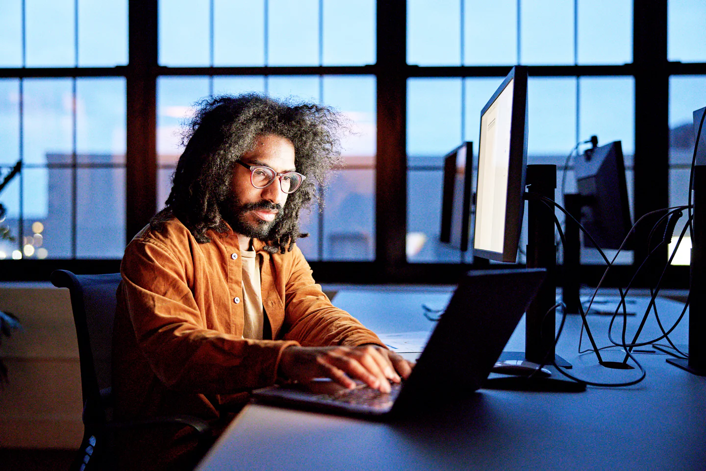 Portrayal of Capella IT student in computer lab with big windows.