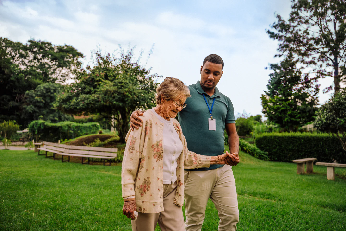 Portrayal of a Capella University online social work graduate&nbsp;helping an elderly woman walk outdoors.