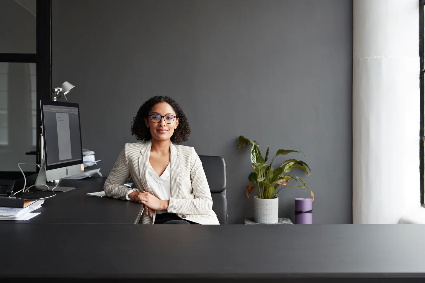 Portrayal of Capella business student sitting at an office desk.