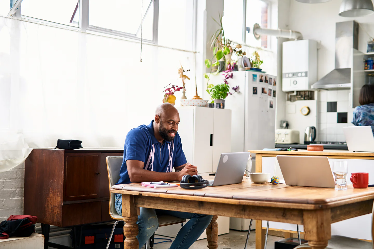 Portrayal of Capella online student using a laptop in his kitchen.