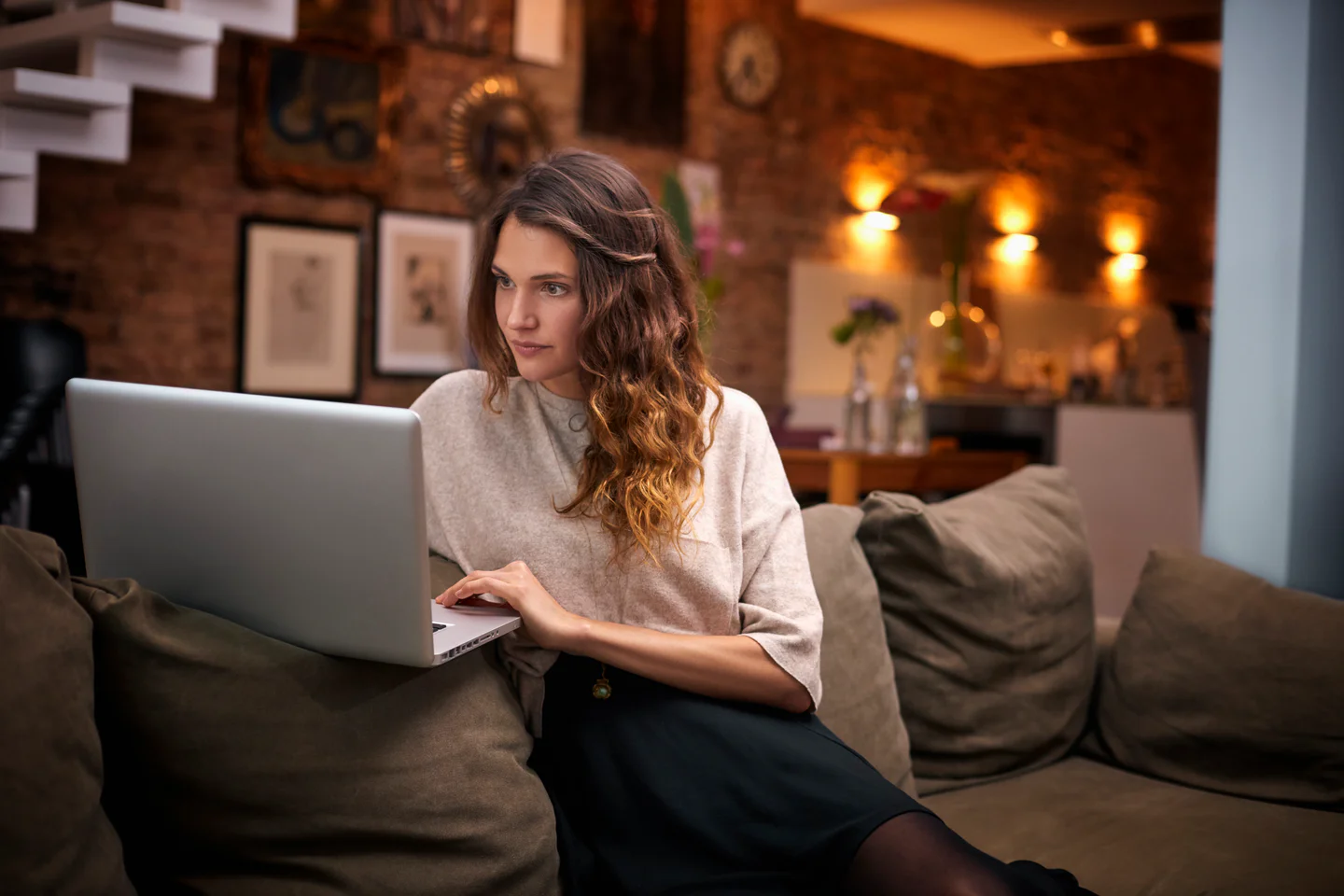 Portrayal of a Capella student using her laptop on the couch.