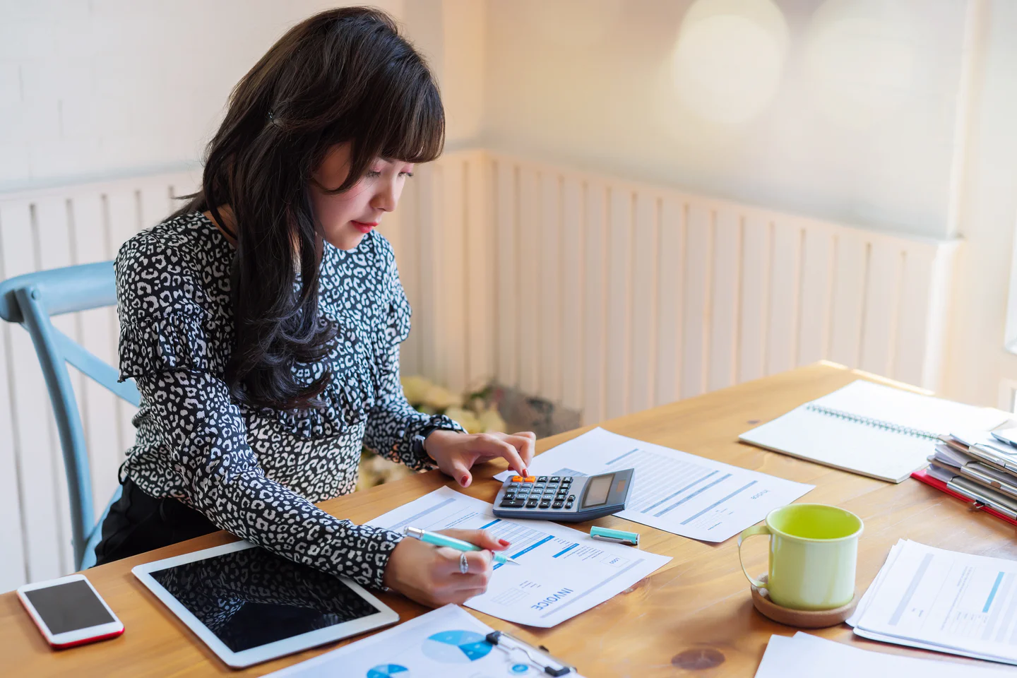 Portrayal of a Capella student sitting at a desk using a calculator.