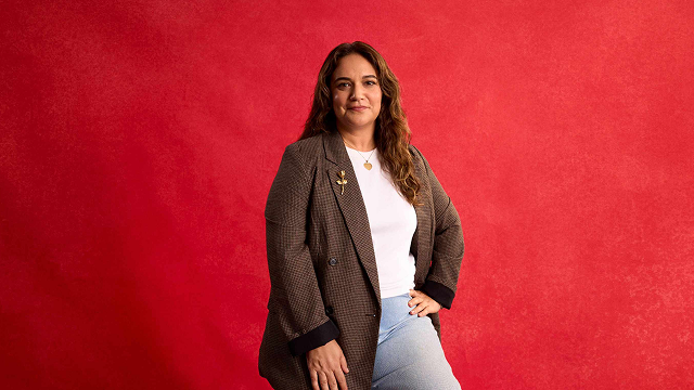 woman in brown blazer sitting on stool