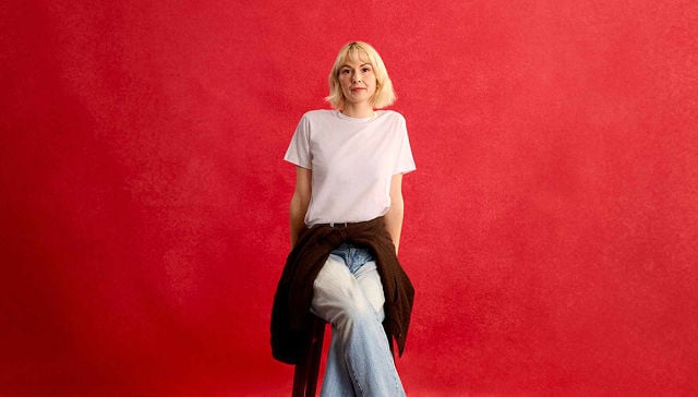 woman in white shirt sitting on a stool