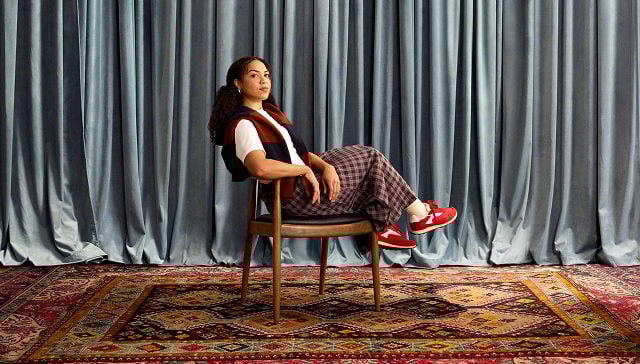 woman confidently leaning back in a wooden chair