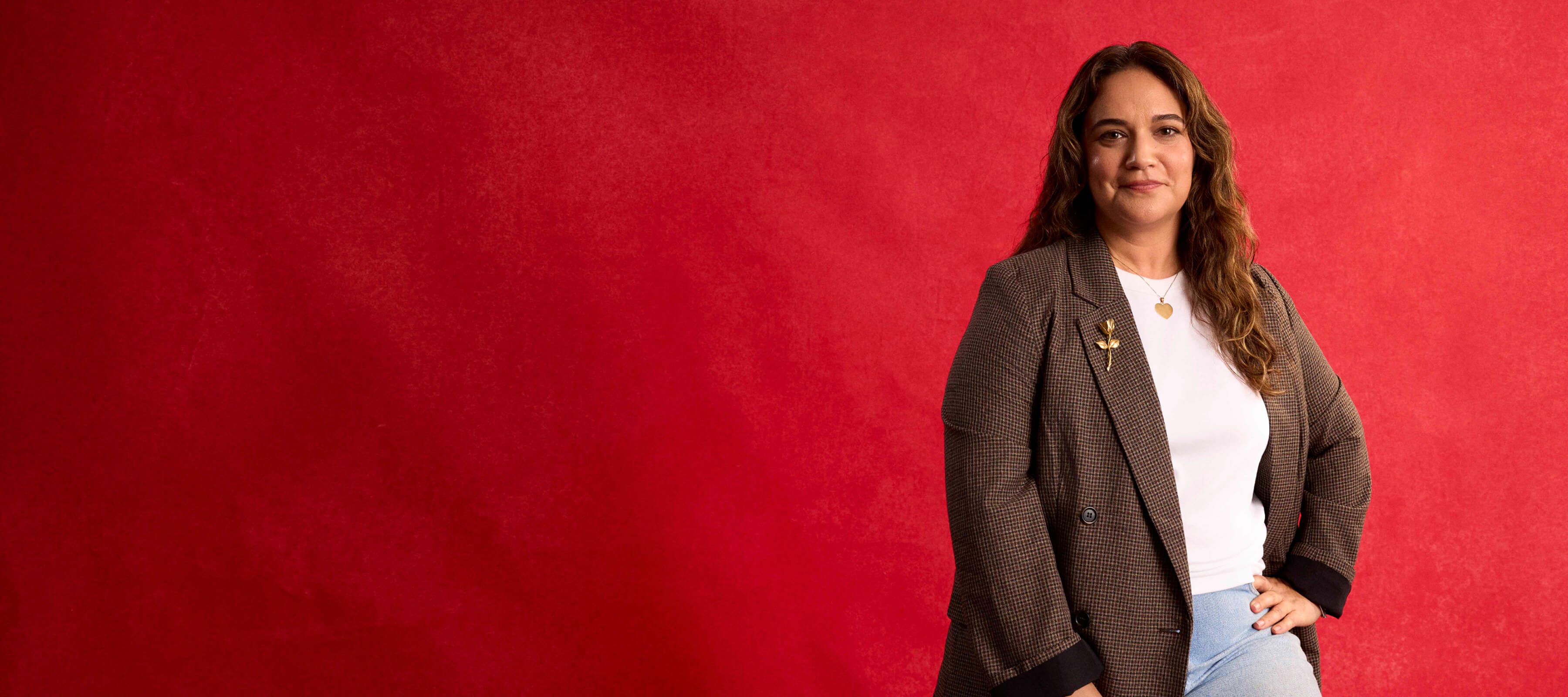 woman in brown blazer sitting on stool
