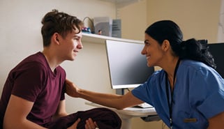 nurse reassuring young male patient
