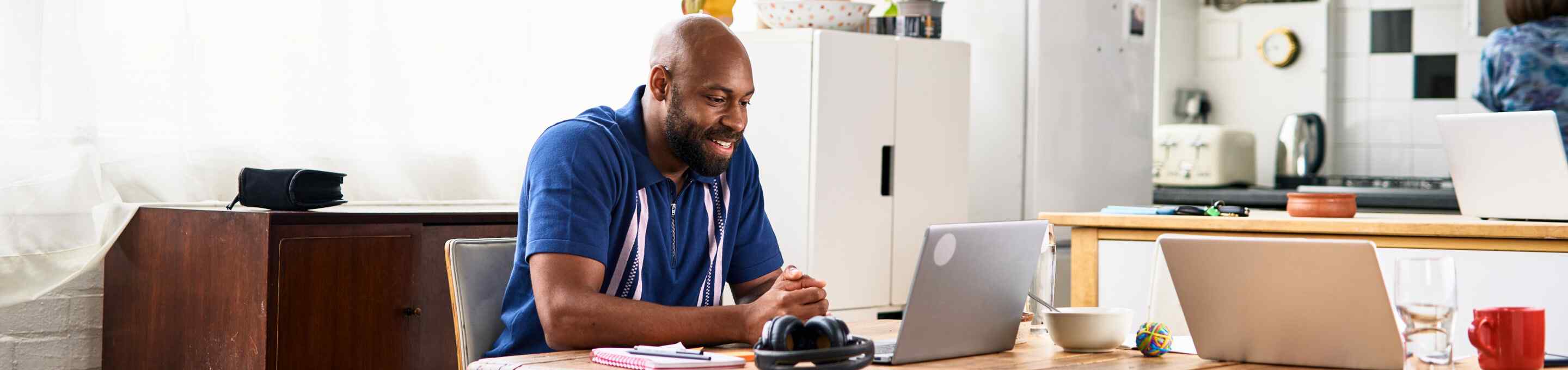 bearded man using a laptop in an apartment