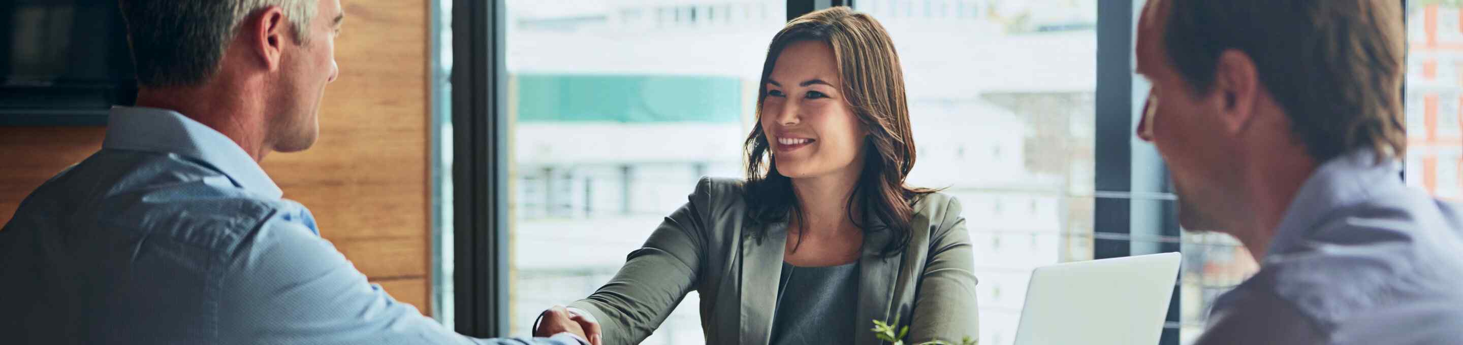 three people shaking hands during a business meeting