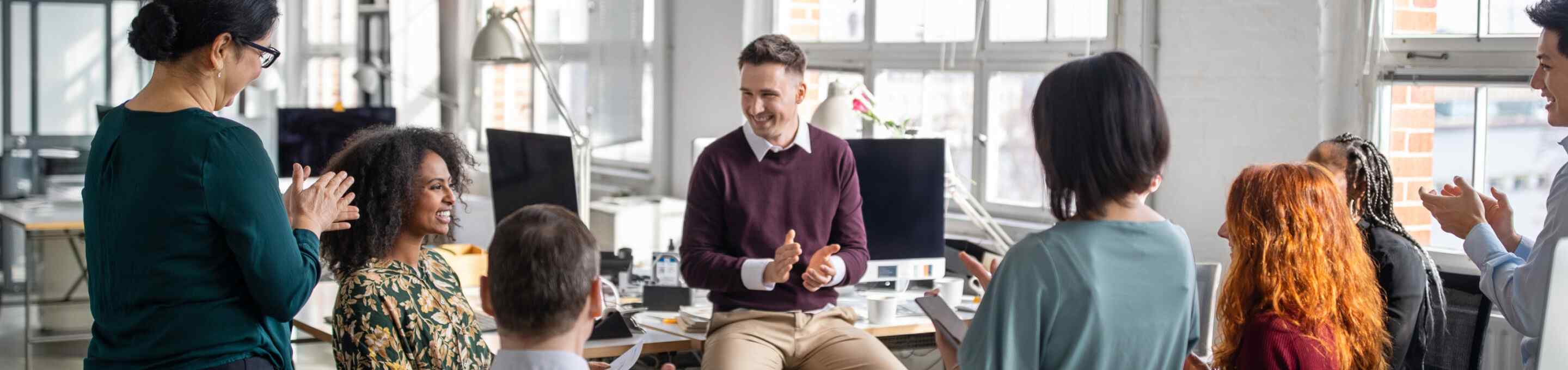 group of team members clapping during a meeting