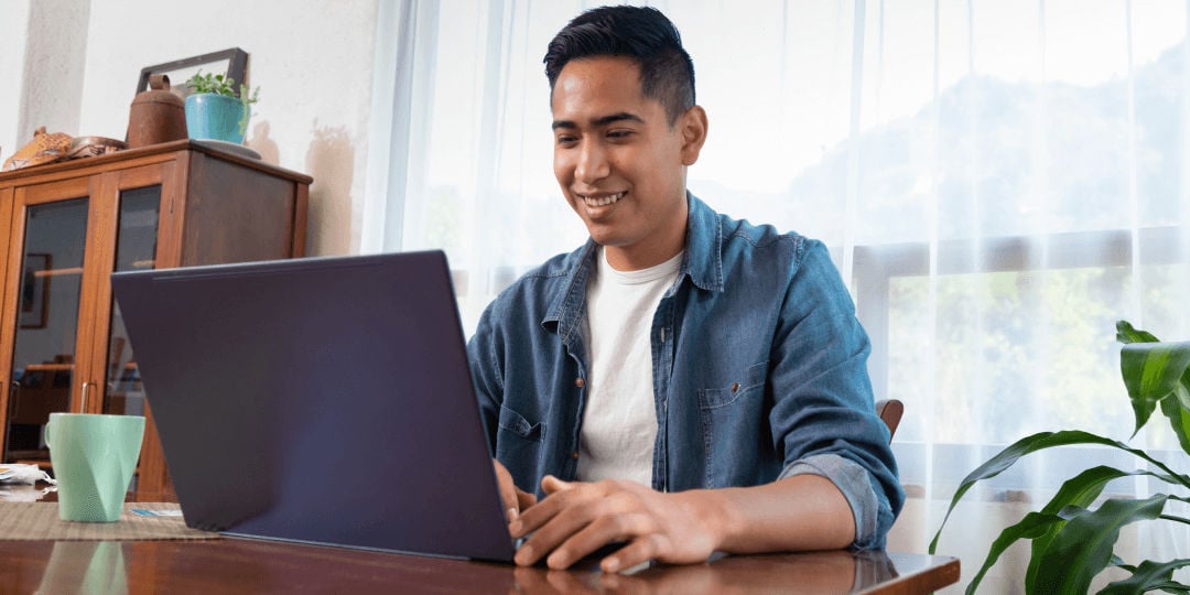 man smiling looking a computer
