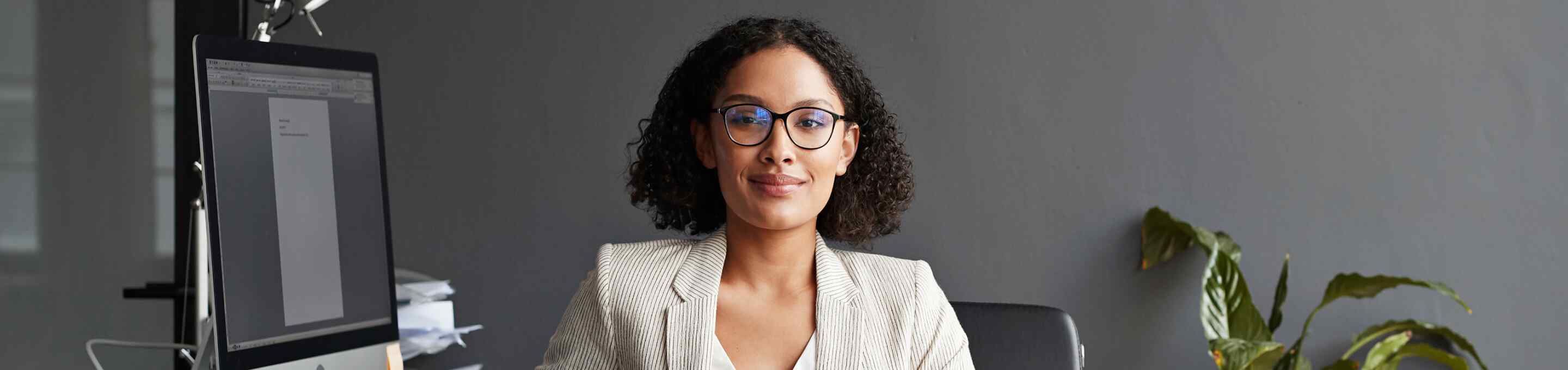 woman smiling wearing a corduroy blazer and glasses