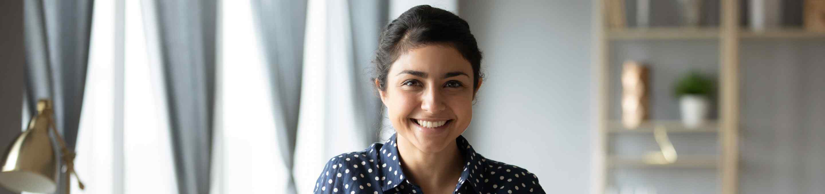 woman wearing a polka dot shirt smiling