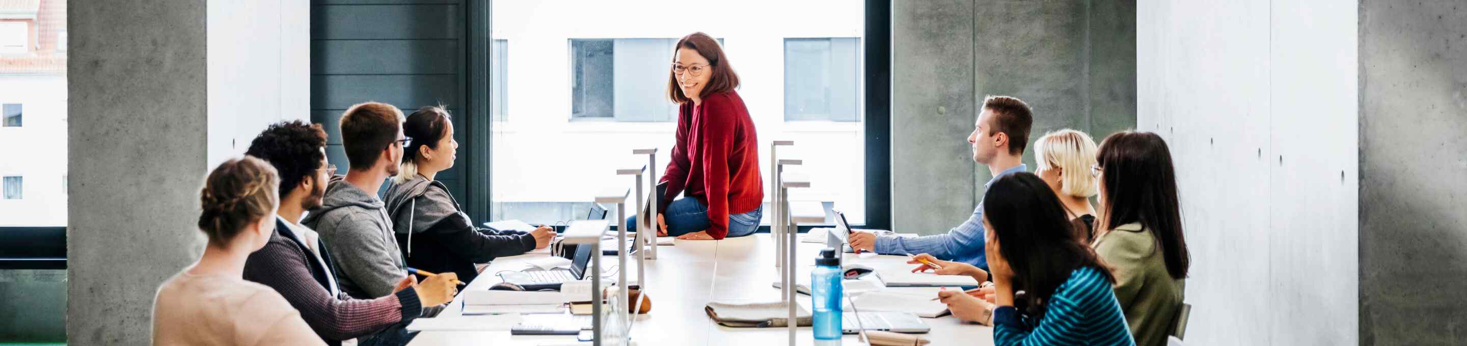 woman in a red sweater leading a team meeting
