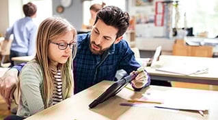 teacher working with student with device
