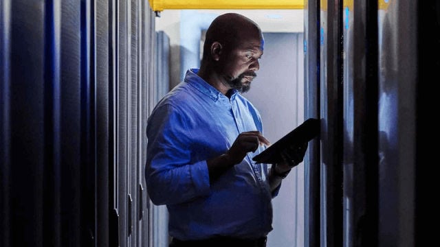 man looking at tablet inside data center