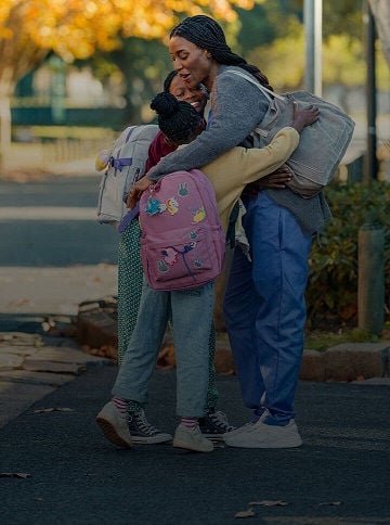Woman hugging two girls.