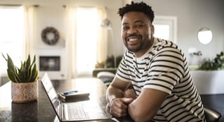 man smiling with laptop open