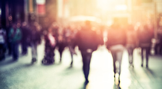 pedestrians walking away into blurry sun