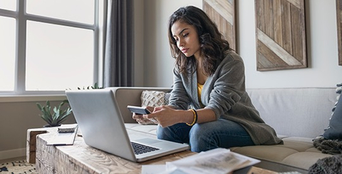calculating costs while looking at a laptop